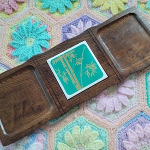 May include: A wooden serving tray with three sections. The center section features a green and gold tile with a bamboo design. The tray is perfect for serving snacks or appetizers.