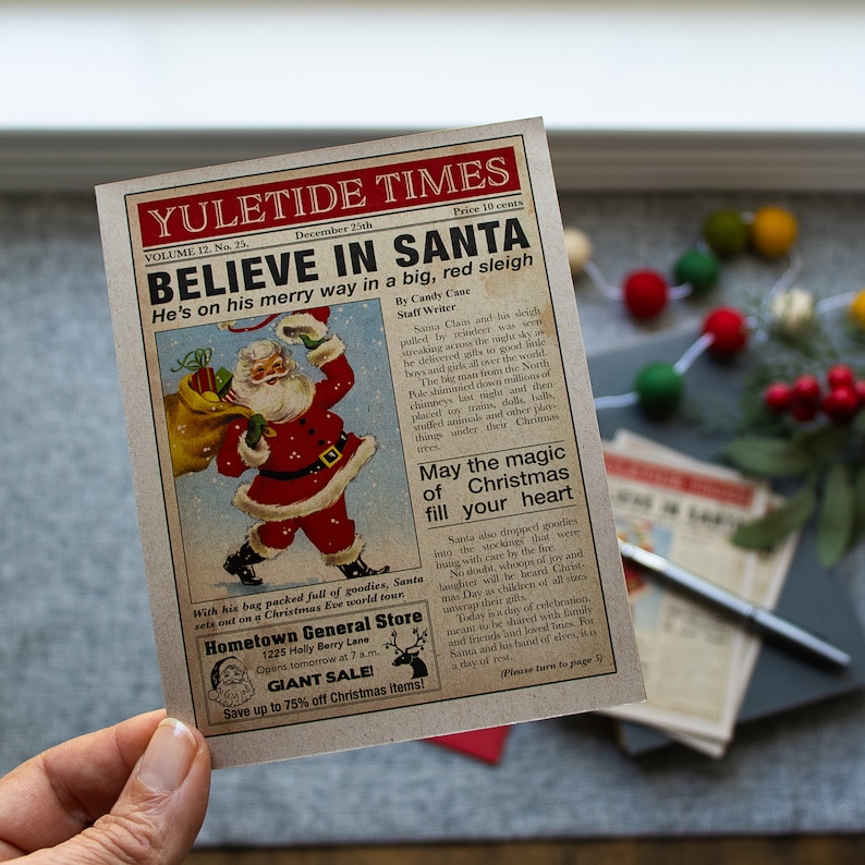 Pu&ograve; includere: Un ritaglio di giornale in stile vintage con un'illustrazione rossa e bianca di Babbo Natale che porta un sacco di regali. Il titolo recita "Credi in Babbo Natale" e il testo descrive il viaggio di Babbo Natale per consegnare i regali la vigilia di Natale. Il giornale pubblicizza anche un negozio locale chiamato "Hometown General Store" con una vendita di articoli natalizi.