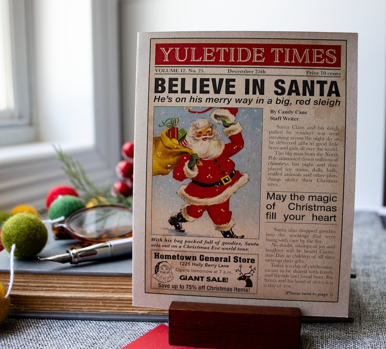 Pu&ograve; includere: Un'illustrazione di giornale vintage di Yuletide Times con Babbo Natale in un abito rosso e una grande slitta rossa, che consegna i regali. Il testo recita "Credi in Babbo Natale" e "&Egrave; in viaggio su una grande slitta rossa".