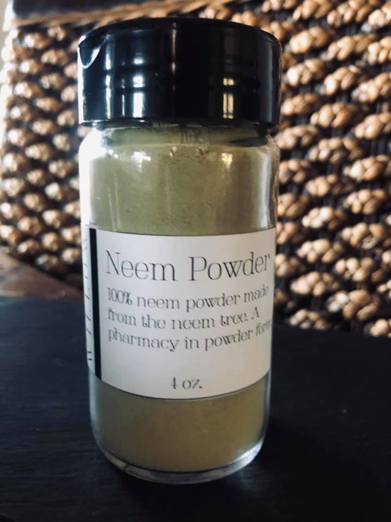 May include: A glass jar with a black lid filled with green neem powder. The label reads "Neem Powder 100% neem powder made from the neem tree. A pharmacy in powder form 4 oz."