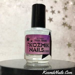 May include: A clear bottle of 13 free peel base nail polish with a silver glitter finish. The bottle has a black cap and a label that says "Kozmik Nails.com" and "13 Free Peel Base".