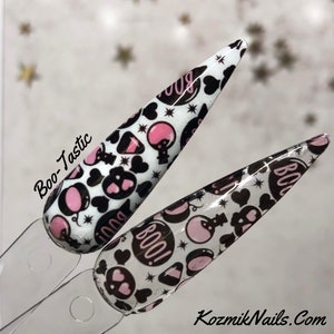 May include: Two nail art samples with a Halloween theme. The nails are white with black and pink designs, including pumpkins, hearts, and the word "BOO!" in a circle. The text "Boo-Tastic" is on the left.