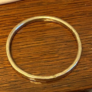 Puede incluir: Un brazalete de plata con acabado martillado.