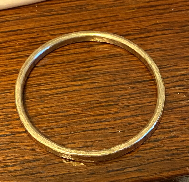 Puede incluir: Un brazalete de plata con acabado martillado.