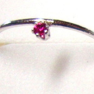 Puede incluir: Un anillo de plata con una pequeña piedra preciosa rosa brillante.