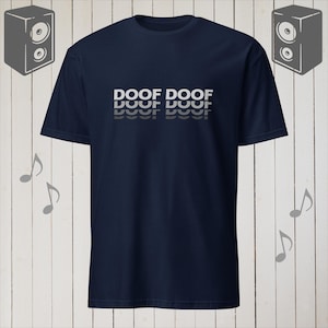 May include: A navy blue t-shirt with the text "DOOF DOOF" printed in white on the front. The text is repeated three times, with each repetition slightly smaller and lighter than the one above it.