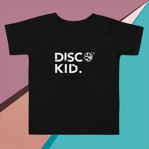 May include: Black t-shirt with a white graphic that says "DISCO KID." The graphic includes a white disco ball with stars.