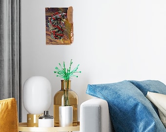 Op de afbeelding: Een mosterdgele fauteuil met een zwart-wit geruit kussen staat in een woonkamer met een grijze bank en een kleine houten bijzettafel. Een klein abstract schilderij hangt aan de muur boven de tafel.
