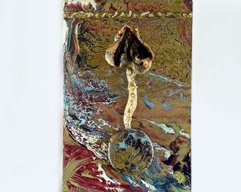 Op de afbeelding: Abstract schilderij op canvas met een driedimensionaal paddenstoelsculptuur in het midden. De paddenstoel is bruin en goudkleurig met een witte steel. De achtergrond is een mix van gouden, blauwe, rode en witte verf.