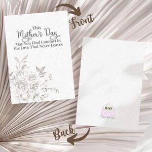 Puede incluir: Una tarjeta blanca del D&iacute;a de la Madre con ilustraciones florales y el texto "This Mother's Day, May You Find Comfort in the Love That Never Leaves." La parte posterior de la tarjeta presenta un logotipo con el texto "JEISY Paper Dreams."