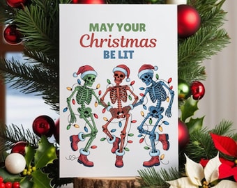 Könnte beinhalten: Weihnachtskarte mit dem Text "MAY YOUR Christmas BE LIT". Die Karte zeigt drei tanzende Skelette mit Weihnachtsmützen und eingewickelt in Lichterketten. Die Karte ist von Weihnachtsdekorationen umgeben.