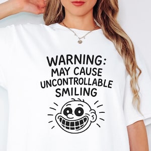 スマイリーフェイスの警告Tシャツ - 思わず笑顔になってしまう面白い漫画Tシャツ。ハッピーな気分にさせてくれるユーモアあふれるギフトアイデア