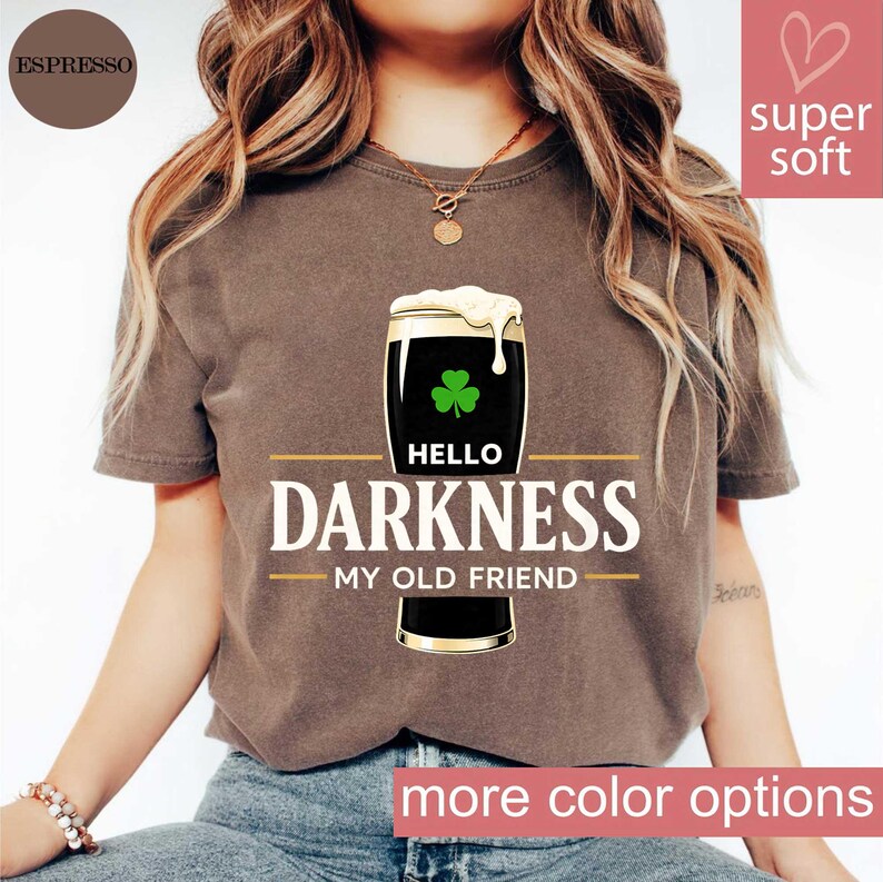 May include: Espresso-colored t-shirt featuring a graphic of a pint of stout with a shamrock and the text "Hello Darkness My Old Friend." The shirt has a relaxed fit and is made of a soft material.