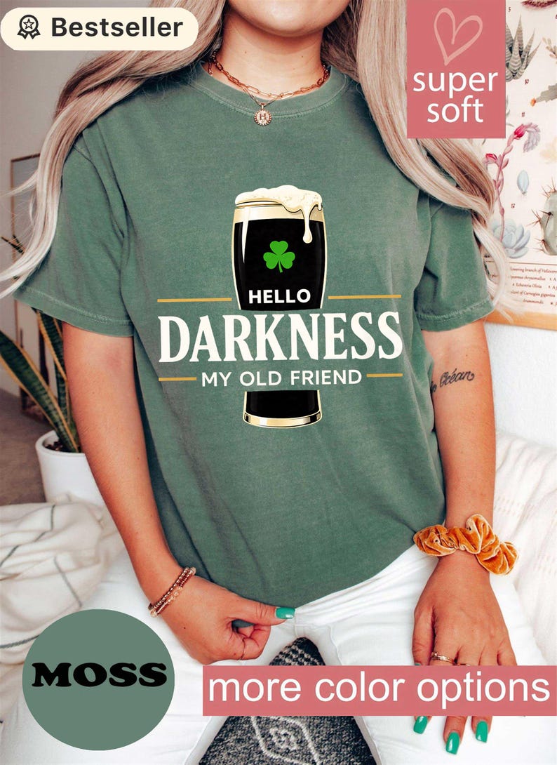 May include: Moss green t-shirt with a graphic of a pint of stout beer with a shamrock and the text "Hello Darkness My Old Friend". The shirt is labeled "Bestseller" and "Super Soft".