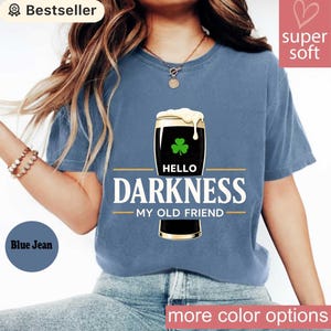 May include: Blue jean colored t-shirt with the text "HELLO DARKNESS MY OLD FRIEND" and a graphic of a dark stout beer with a shamrock. The shirt is labeled "Bestseller" and "Super Soft".