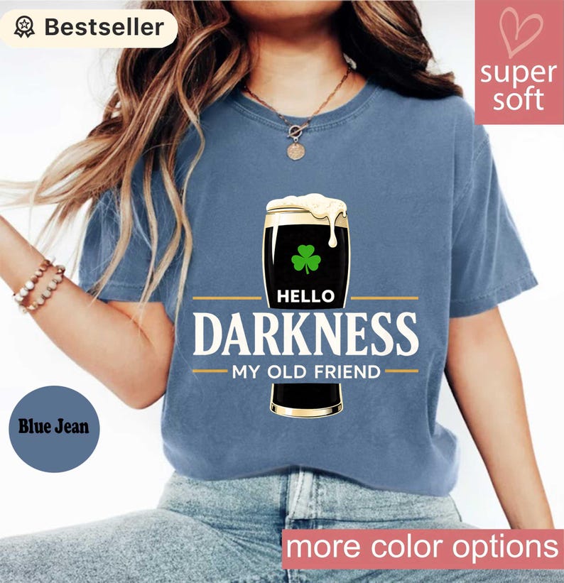 May include: Blue jean colored t-shirt with the text "HELLO DARKNESS MY OLD FRIEND" and a graphic of a dark stout beer with a shamrock. The shirt is labeled "Bestseller" and "Super Soft".