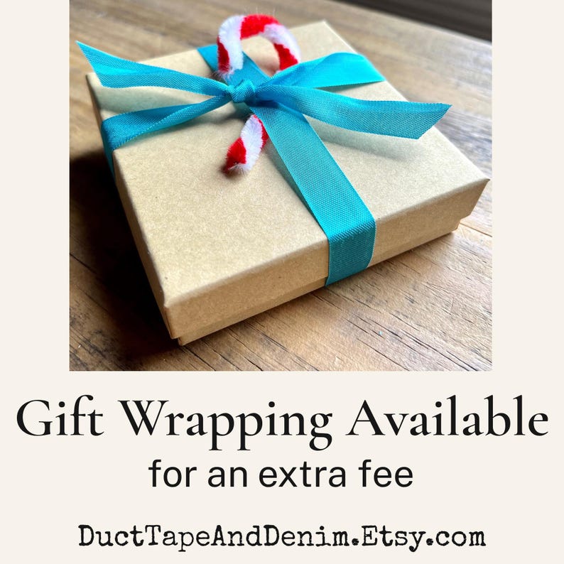 May include: A square tan cardboard gift box tied with a bright turquoise ribbon and a small red and white striped candy cane ornament. The text below reads: Gift Wrapping Available for an extra fee DuctTapeAndDenim.Etsy.com.