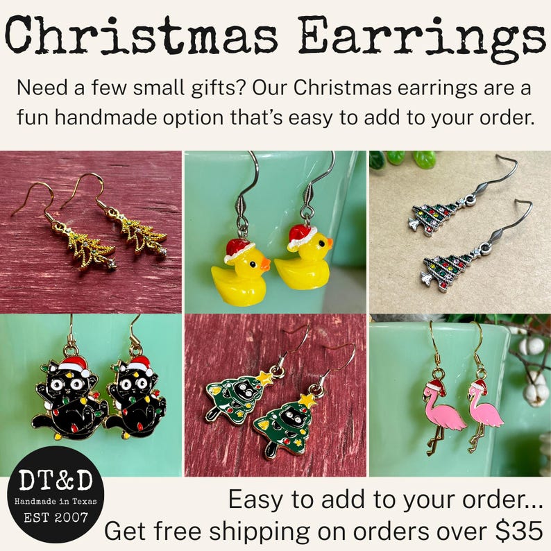 May include: A collection of six pairs of Christmas-themed dangle earrings featuring gold-tone and silver-tone metal hooks. Designs include yellow rubber ducks with Santa hats, black cats with holiday lights, pink flamingos, and various Christmas trees.