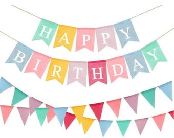 May include: A colorful Happy Birthday banner with pastel colored flags. The flags are strung together with white string. The letters are white and the flags are in the colors of pink, blue, yellow, and green.