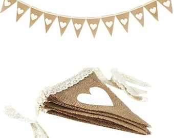 May include: A rustic burlap banner with white heart cutouts, perfect for weddings or parties. The banner features triangular flags with a white heart in the center. A stack of matching flags with lace trim is also visible.