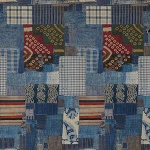 May include: Blue patchwork wallpaper with a variety of patterns, including checks, stripes, and paisley. A white vase with dried flowers stands on a wooden stool. The wallpaper's design incorporates different shades of blue.