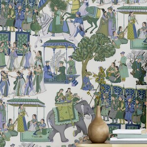 May include: A room featuring a pale yellow dresser with black hardware, a pink armchair, and a framed botanical print. The wallpaper depicts a detailed illustration of a procession with elephants, figures in traditional attire, and architectural elements in shades of green, blue, and white.