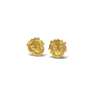 Pu&ograve; includere: Un paio di orecchini a bottone in oro a forma di testa di leone. Gli orecchini sono piccoli e delicati e sarebbero un ottimo regalo per un amico o una persona cara.