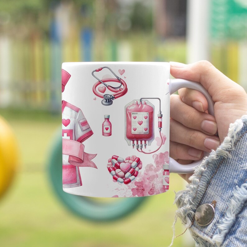 Peut inclure: Mug en c&eacute;ramique blanche orn&eacute; d'illustrations m&eacute;dicales roses et rouges. Les motifs incluent un st&eacute;thoscope, une poche de sang, des pilules et un uniforme d'infirmi&egrave;re. Le mug est tenu par une personne.