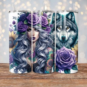 May include: Three stainless steel tumblers with different designs. The first tumbler features a woman with long purple hair and a floral crown. The second tumbler features a wolf with yellow eyes. The third tumbler features a purple rose with green leaves.