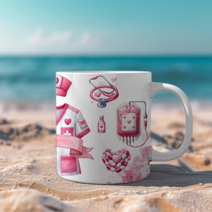 Peut inclure: Mug en c&eacute;ramique blanche avec un th&egrave;me m&eacute;dical rose et blanc. Le motif comprend un uniforme d'infirmi&egrave;re, un st&eacute;thoscope, une poche de sang et des pilules en forme de c&oelig;ur. Le mug est pos&eacute; sur une plage de sable avec la mer en arri&egrave;re-plan.