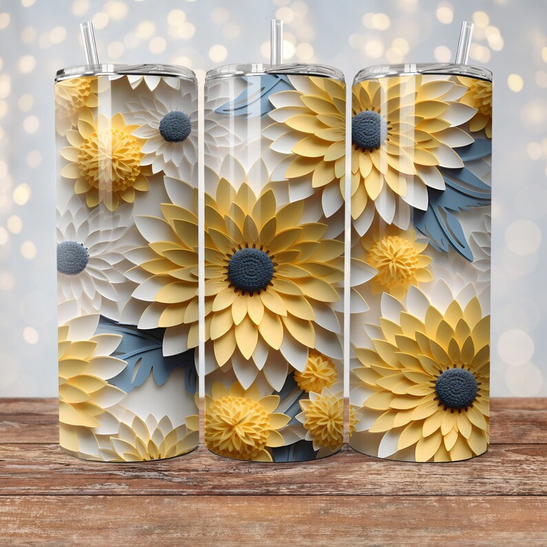 May include: Three stainless steel tumblers with a floral design. The tumblers feature a pattern of yellow, white, and blue paper flowers.