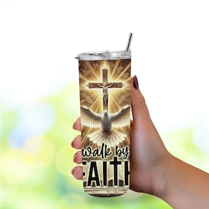 May include: A stainless steel tumbler with a religious design. The design features a cross with Jesus, a dove, and the words "walk by FAITH" in black. The tumbler has a silver straw and a clear lid. The background is a golden glow.
