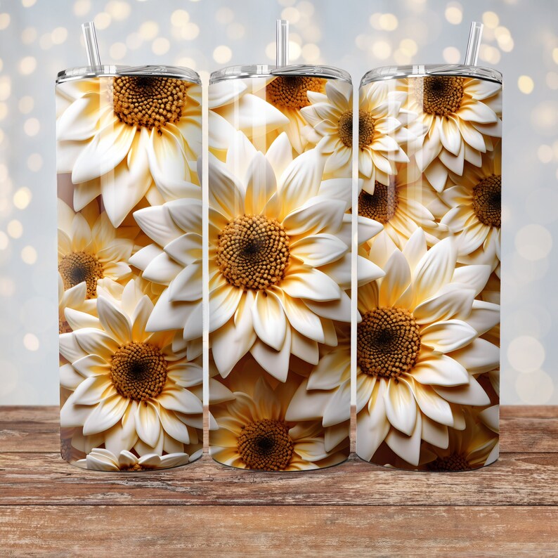 May include: A white and yellow sunflower pattern on a stainless steel tumbler. The tumbler has a straw and a lid.
