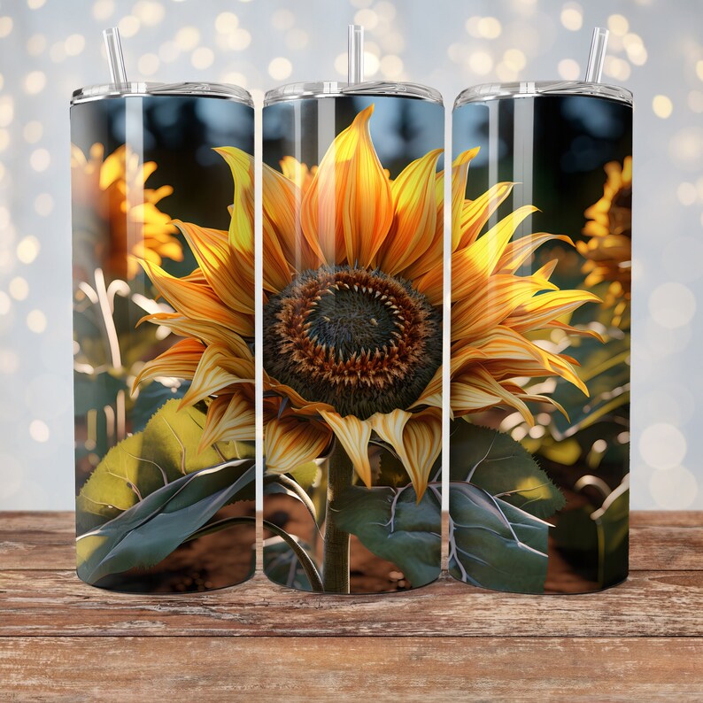 May include: Three stainless steel tumblers with a sunflower design. The tumblers are in focus and the background is blurred. The sunflowers are yellow and orange with green leaves.