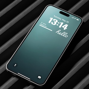 Może przedstawiać: Smartfon z ciemnozielonym ekranem, na którym wyświetla się godzina 13:14 i data wtorek, 20 maja. Tekst "hello" jest wyświetlany pod godziną. Telefon leży na czarno-szarej powierzchni w paski.