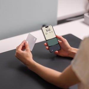 a person holding a cell phone and a card