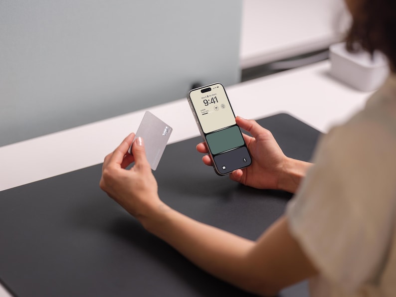 a person holding a cell phone and a card