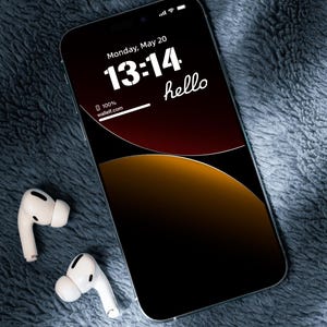 a cell phone with ear buds laying on a blanket