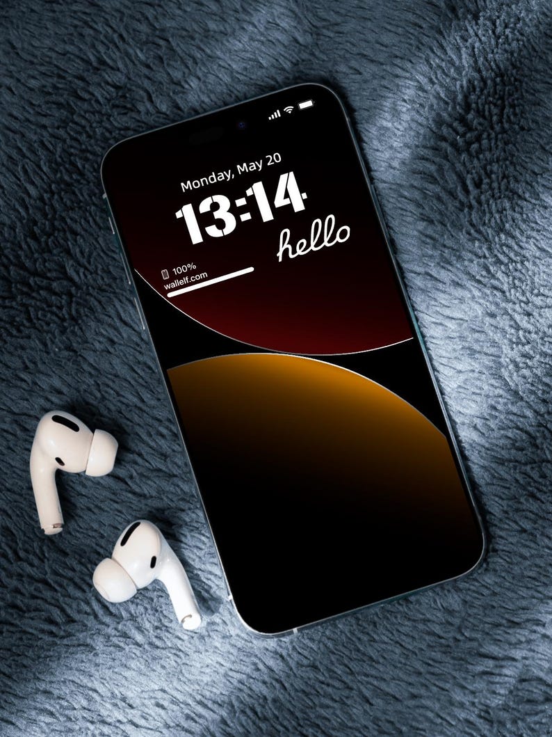 a cell phone with ear buds laying on a blanket