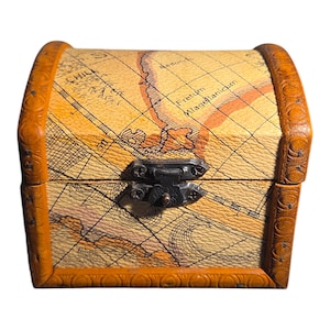 May include: A small, closed treasure chest with a map design. The chest is tan with a brown border and a metal clasp. The map design includes lines and text, with a vintage aesthetic. The chest is likely made of wood or a similar material.