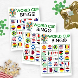 May include: Three sheets of World Cup Bingo cards with country flags, the text "WORLD CUP BINGO", and the year "2026". The cards feature flags of various nations, including the USA, Brazil, and England. Green confetti and a gold star-shaped dish are in the background.