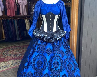Puede incluir: Una falda de brocado azul y negro con un borde de encaje negro y un corsé blanco con detalles negros.