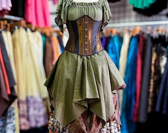 May include: A green and brown corset dress on a mannequin. The dress features a ruffled neckline, a fitted corset with brown and black panels, and a layered skirt with a skull print at the hem. The dress is displayed in a clothing store.
