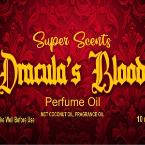 Könnte beinhalten: Ein rotes und goldenes Etikett mit dem Text "Super Scents Dracula's Blood Perfume Oil" und "Shake Well Before Use". Das Etikett enthält auch den Text "MCT Coconut Oil, Fragrance Oil" und "10 ml".