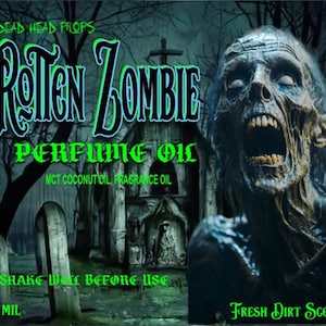 May include: A green and black label with the text "Rotten Zombie Perfume Oil" and "Fresh Dirt Scent". The label features a zombie face with a large open mouth and a graveyard scene in the background. The label also includes the text "Dead Head Props" and "10 ml".