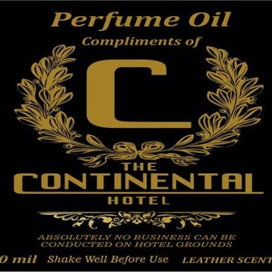 Może przedstawiać: Czarno-złota etykieta z tekstem "Perfume Oil" i "Compliments of The Continental Hotel". Etykieta zawiera również złotą literę "C" z wiankiem laurowym i tekstem "Absolutnie żadne interesy nie mogą być prowadzone na terenie hotelu". Etykieta zawiera również tekst "10 ml Wstrząsnąć przed użyciem Skórzany zapach".