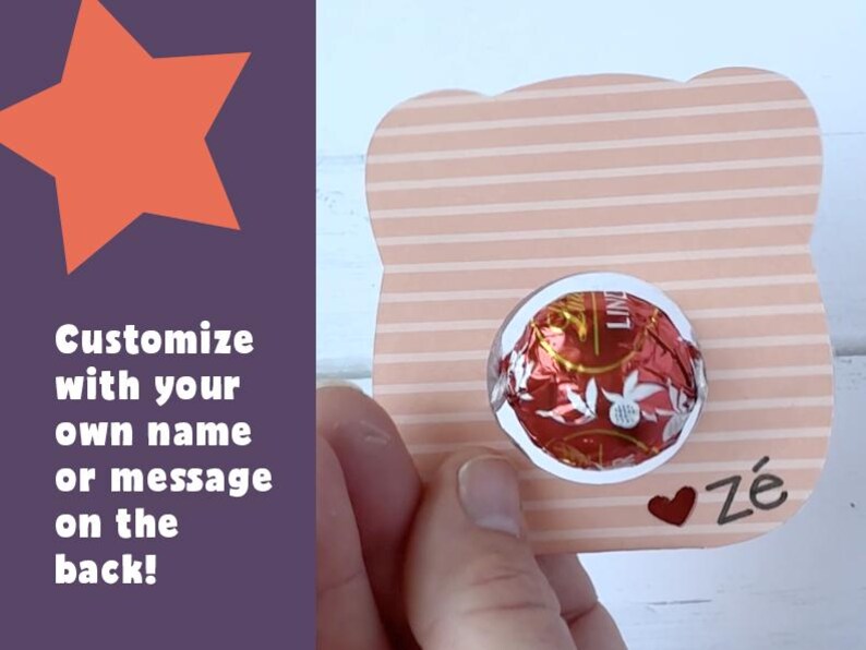 Puede incluir: Una tarjeta de rayas rosa claro y blanco con un recorte redondo para un chocolate. La tarjeta tiene un coraz&oacute;n rojo y el texto "Z&eacute;" escrito en negro. La parte posterior de la tarjeta se puede personalizar con un nombre o un mensaje.