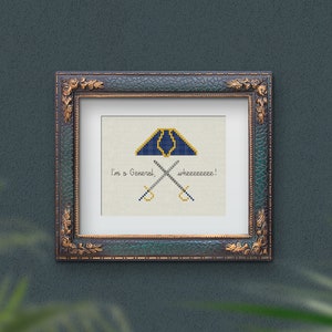 Puede incluir: Un diseño de punto de cruz enmarcado que presenta un sombrero militar azul y dorado con espadas cruzadas y el texto "I'm a General, wheeeeeee!"