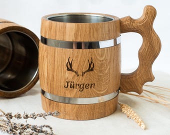 Op de afbeelding: Een houten bierpul met een roestvrijstalen voering. De pul heeft een handvat en is gegraveerd met geweien en de naam "Juergen".
