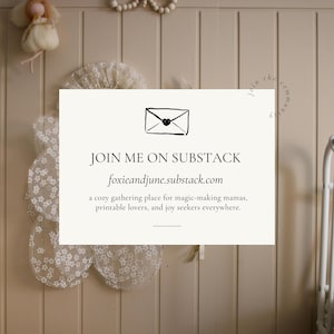 May include: A cream-colored sign with the text "JOIN ME ON SUBSTACK" and the website foxieandjune.substack.com. The sign is decorated with a black envelope icon and the text "a cozy gathering place for magic-making mamas, printable lovers, and joy seekers everywhere."